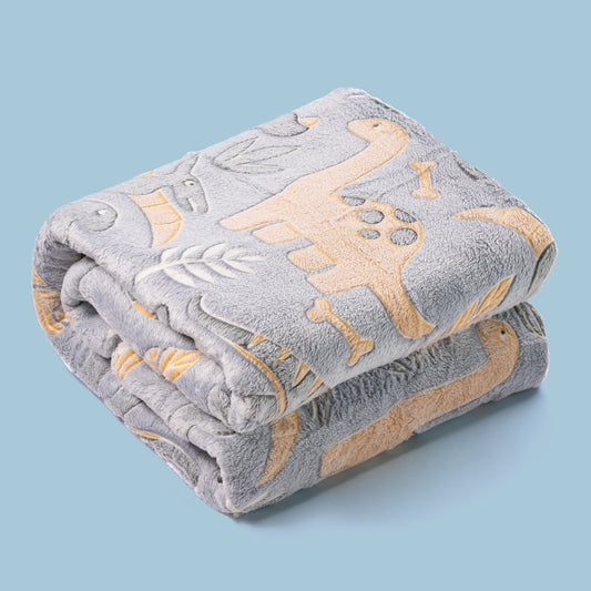 DInosaur blanket that glows in the dark folded on coloured background