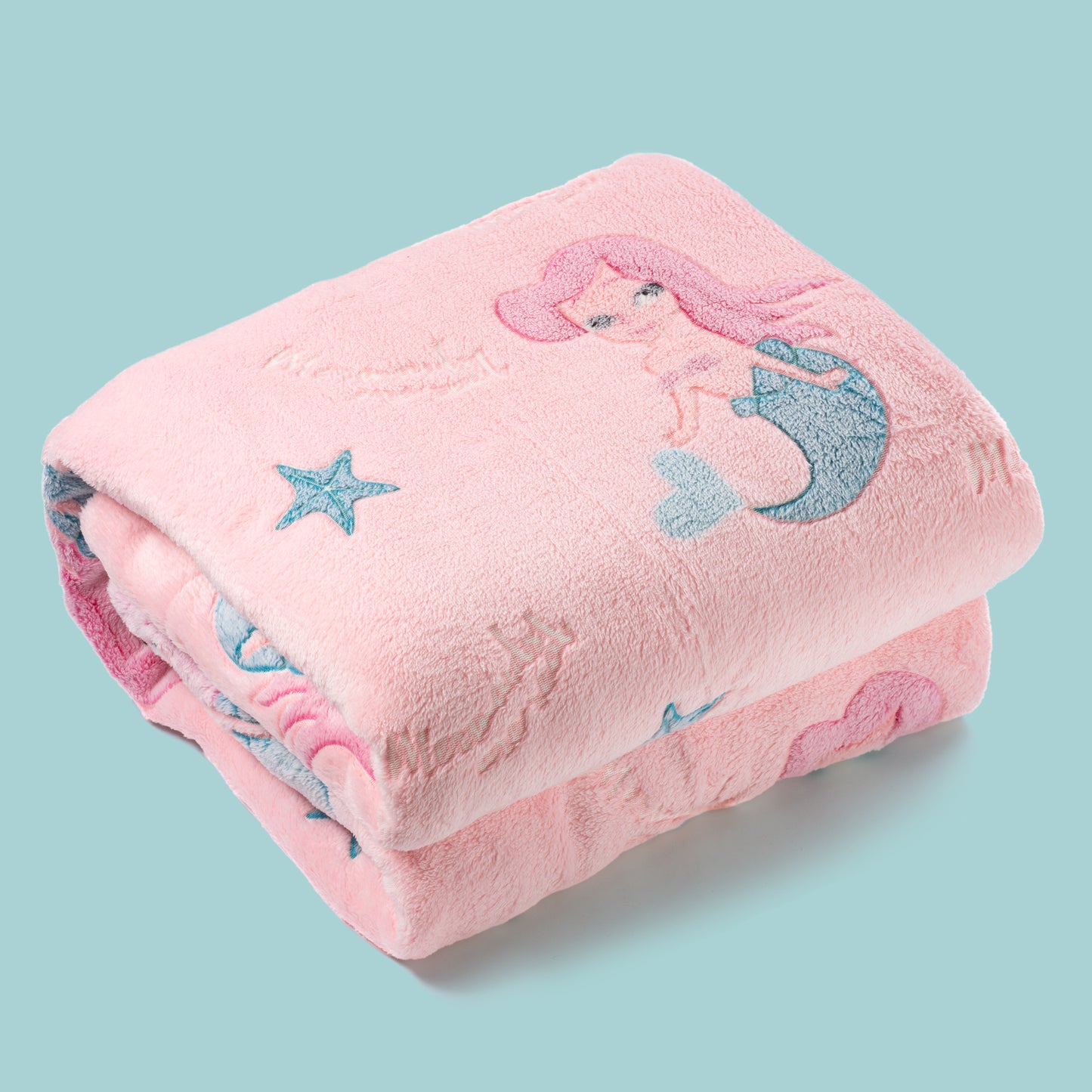 Pink mermaid blanket neatly folded on turquoise background