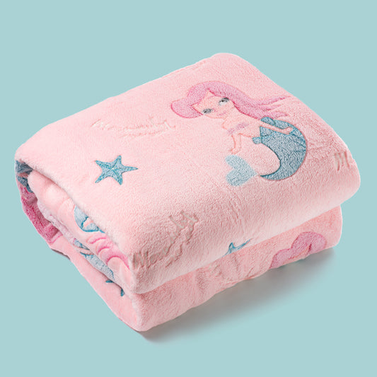 Pink mermaid blanket neatly folded on turquoise background